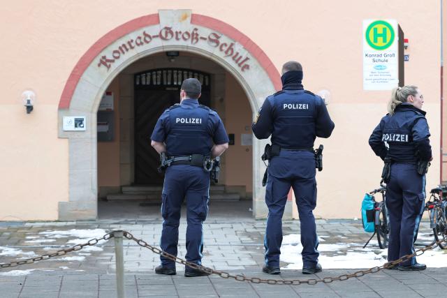 05 February 2026, Nuremberg: Police officers stand in front of a Nuremberg school where a pupil was reportedly spotted with a suspected weapon. Police were on the scene with officers and special task forces. Photo: Daniel Löb/dpa