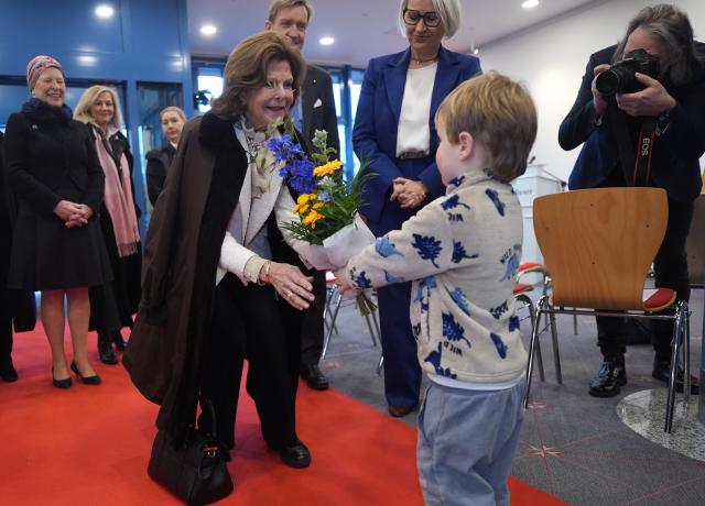 05 February 2026, Schleswig-Holstein, Flensburg: Jonne (R), four years old boy from Maltesa's St. Marien daycare center, presents Queen Silvia of Sweden (L) with a bouquet of flowers during her visit to the geriatric day clinic at St. Franziskus Hospital. Queen Silvia visits the Silvia dementia ward named after her. Photo: Marcus Brandt/dpa