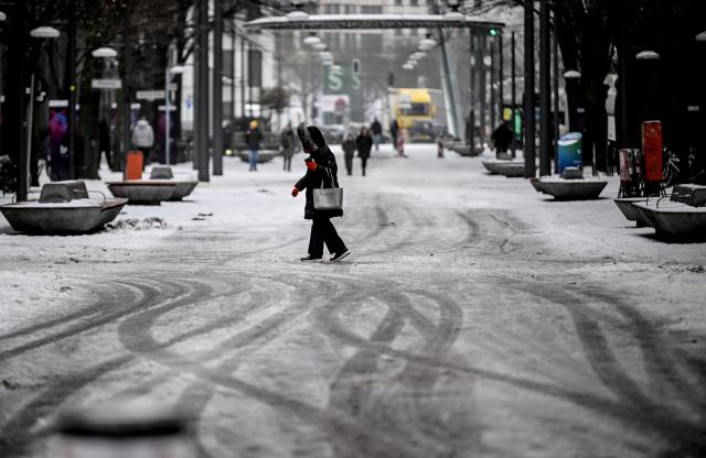 06 February 2026, Berlin: Passersby walk through slush at Potsdamer Platz. Photo: Britta Pedersen/dpa