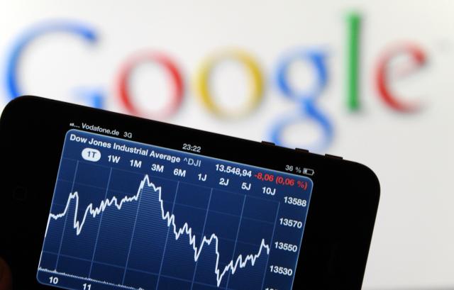 FILED - 18 October 2012, Hamburg: A cell phone displaying the Dow Jones stock market index is held in front of a Google logo in Hamburg. Photo: picture alliance / dpa