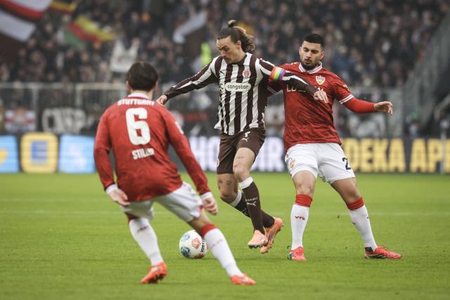 07 February 2026, Hamburg: St. Pauli's Jackson Irvine (C) battles for the ball with Stuttgart's Deniz Undav and Angelo Stiller during the German Bundesliga soccer match between FC St. Pauli and VfB Stuttgart at Millerntor Stadium. Photo: Christian Charisius/dpa - WICHTIGER HINWEIS: Gemäß den Vorgaben der DFL Deutsche Fußball Liga bzw. des DFB Deutscher Fußball-Bund ist es untersagt, in dem Stadion und/oder vom Spiel angefertigte Fotoaufnahmen in Form von Sequenzbildern und/oder videoähnlichen Fotostrecken zu verwerten bzw. verwerten zu lassen.
