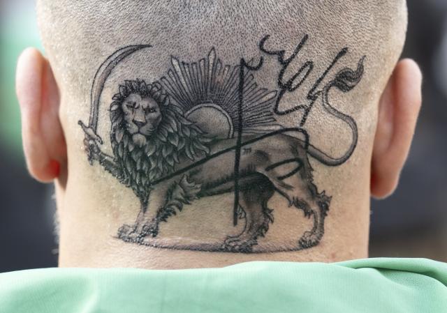 07 February 2026, Hesse, Frankfurt_Main: A man has tattooed the "Persian lion" on the back of his head during a demonstration in downtown Frankfurt against the government in Tehran and in solidarity with the popular uprising in Iran. Photo: Boris Roessler/dpa