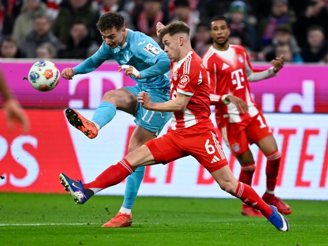 08 February 2026, Bavaria, Munich: Bayern Munich's Joshua Kimmich (R) and Hoffenheim's Fisnik Asllani battle for the ball during the German Bundesliga soccer match between Bayern Munich and TSG 1899 Hoffenheim at the Allianz Arena. Photo: Sven Hoppe/dpa - IMPORTANT NOTE: In accordance with the regulations of the DFL German Football League and the DFB German Football Association, it is prohibited to utilize or have utilized photographs taken in the stadium and/or of the match in the form of sequential images and/or video-like photo series.