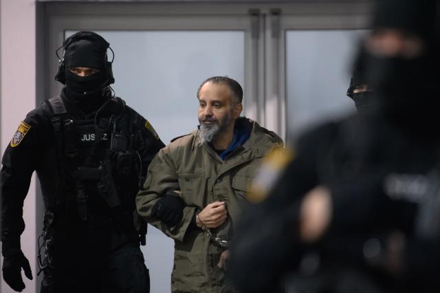 09 February 2026, Saxony-Anhalt, Magdeburg: Court officials escort defendant Taleb al-Abdulmohsen (C) into the courtroom of the temporary courthouse of the Magdeburg Regional Court as proceedings resume in the trial over the fatal incident at the Magdeburg Christmas market. German prosecutors have charged the Saudi Arabian national with attempted murder in 338 cases. Photo: Klaus-Dietmar Gabbert/dpa