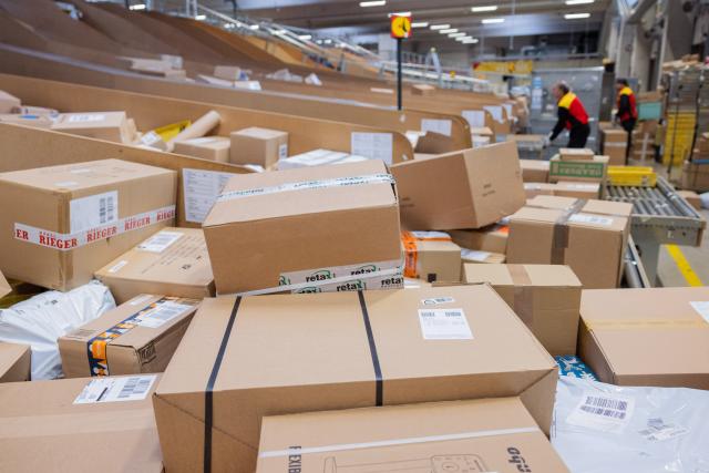 FILED - 04 December 2025, Nordrhein-Westfalen, Köln: Parcel delivery drivers sort and load parcels into delivery vehicles at a Deutsche Post DHL delivery depot. German prosecutors have charged a third suspect over planning a foiled parcel bombing plot on behalf of Russian intelligence, the Federal Public Prosecutors' Office said on Monday. Photo: Rolf Vennenbernd/dpa
