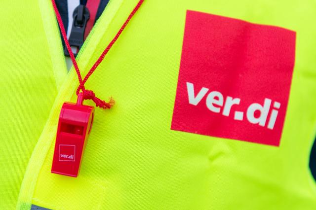 FILED - 10 April 2018, Berlin: A striker wears a safety vest with the Verdi logo and a red whistle. Photo: Christophe Gateau/dpa