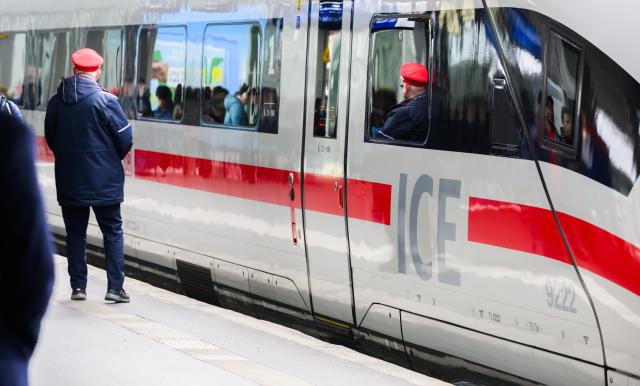 FILED - 18 March 2024, Lower Saxony, Hanover: A railway employee stands next to an ICE train at Hanover Central Station. Photo: Julian Stratenschulte/dpa