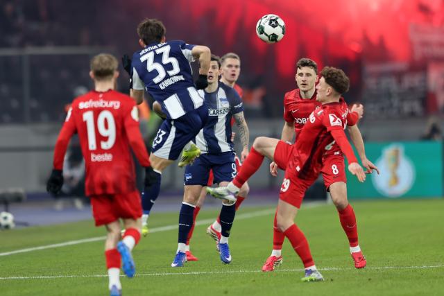 10 February 2026, Berlin: Hertha's Michal Karbownik and and Freiburg's Philipp Treu battle for the ball during the German DFB Cup quarter-final soccer match between Hertha BSC and SC Freiburg at Olympiastadion. Photo: Andreas Gora/dpa