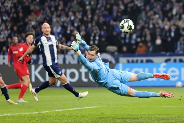 10 February 2026, Berlin: Freiburg goalkeeper Florian Mueller saves the ball during the German DFB Cup quarter-final soccer match between Hertha BSC and SC Frei burg at Olympiastadion. Photo: Andreas Gora/dpa