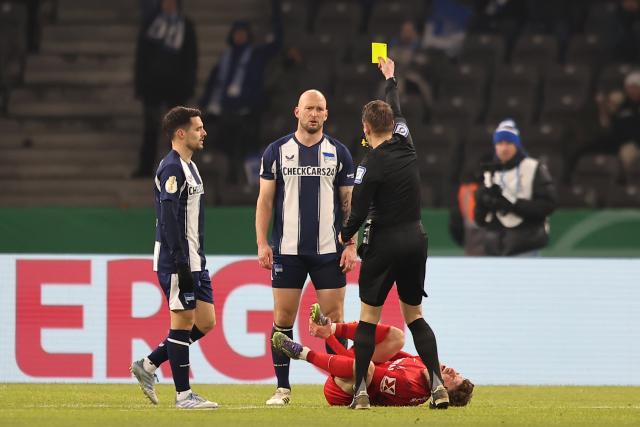 10 February 2026, Berlin: Hertha's Toni Leistner is shown a yellow card by Patrick Ittrich during the German DFB Cup quarter-final soccer match between Hertha BSC and SC Freiburg at Olympiastadion. Photo: Andreas Gora/dpa