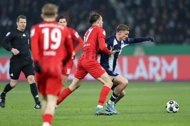 10 February 2026, Berlin: Freiburg's Max Rosenfelder and Hertha's Michael Cuisance battle for the ball during the German DFB Cup quarter-final soccer match between Hertha BSC and SC Freiburg at Olympiastadion. Photo: Andreas Gora/dpa