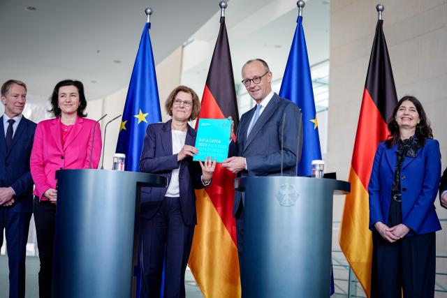 11 February 2026, Berlin: German Chancellor Friedrich Merz accepts the report of the Commission of Experts for Research and Innovation (EFI) alongside Joachim Henkel, TU Munich, Dorothee Baer (CSU), Federal Minister for Research, Technology and Space, Irene Bertschek, Justus Liebig University Giessen, and Carolin Haeussler, University of Passau. The commission advises the Federal Government and submits an annual report with recommendations on research, innovation and Germany's technological performance. Photo: Kay Nietfeld/dpa