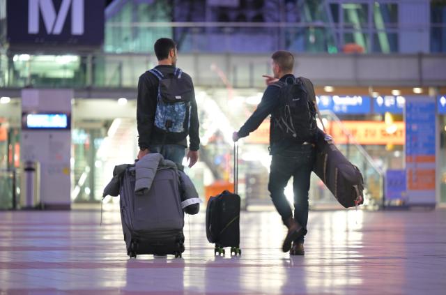 12 February 2026, Bavaria, Munich: Flight passengers with wheeled suitcases walk through the central area of Munich Airport. On Thursday, Lufthansa pilots and flight attendants go on a full-day strike at the same time. Photo: Malin Wunderlich/dpa