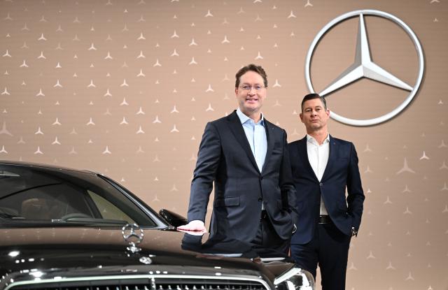 12 February 2026, Baden-Württemberg, Sindelfingen: Ola Kaellenius (l), Chairman of the Board of Management of Mercedes-Benz Group AG, and Harald Wilhelm (r), Chief Financial Officer, stand in front of a Mercedes-Benz brand logo on a Mercedes-Benz S-Class vehicle before the balance sheet press conference. Photo: Bernd Weißbrod/dpa
