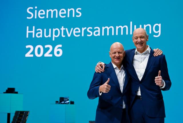 12 February 2026, Bavaria, Munich: Roland Busch (R), Chairman of the Managing Board of Siemens AG, and Ralf P. Thomas, Chief Financial Officer of Siemens AG, stand on stage ahead of the Annual General Meeting. Photo: Sven Hoppe/dpa