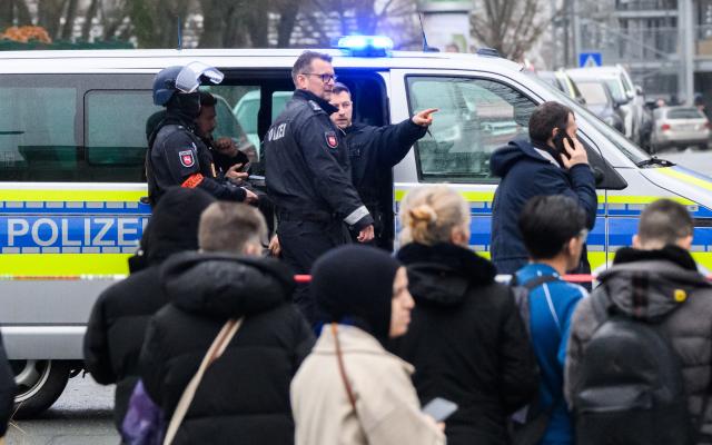 12 February 2026, Lower Saxony, Salzgitter: Police officers stand outside a vocational school on Hans-Boeckler-Ring after authorities detained a minor following a tip-off about a potentially suspicious person at a school in Salzgitter. Photo: Julian Stratenschulte/dpa