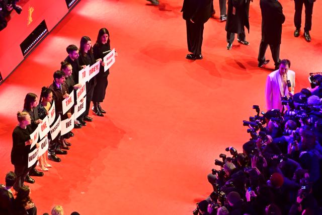 12 February 2026, Berlin: People hold posters reading "No one has the right to obey. Hannah Arendt" on the red carpet in front of the Berlinale Palast, on the opening night of the 76th Berlin International Film Festival. Photo: Sebastian Christoph Gollnow/dpa