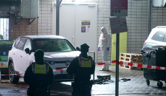 13 February 2026, Hamburg: A forensic investigator examines the parking lot of a restaurant in Hamburg. Following a physical altercation at the establishment, one person has died from their injuries. Photo: Gerald Wintzer/dpa - ACHTUNG: Kennzeichen wurde aus rechtlichen Gründen gepixelt