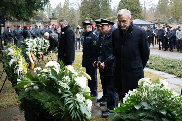 13 February 2026, Saxony, Dresden: Armin Schuster, Saxony's Interior Minister, stands before a wreath during a memorial service at Nordfriedhof cemetery. On February 13-14, 1945, Allied bombers destroyed Dresden's city center on the Elbe, killing up to 25,000 people. Photo: Sebastian Kahnert/dpa