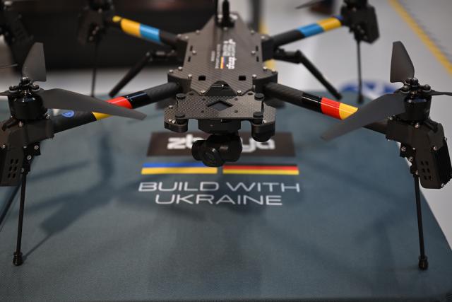 13 February 2026, Bavaria, ---: Ukrainian President Volodymyr Zelensky is presented with a drone during a visit to drone manufacturer Quantum Frontline Industries ahead of the Munich Security Conference. Photo: Sven Hoppe/dpa