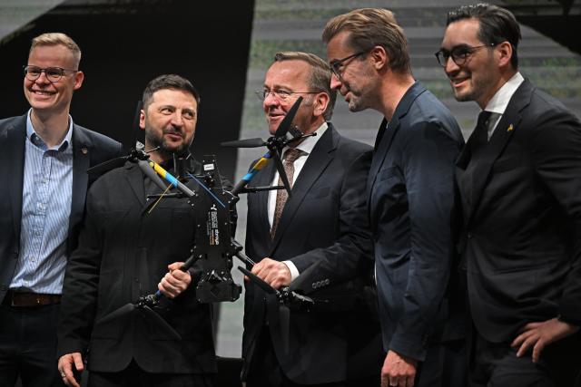 13 February 2026, Bavaria, ---: Volodymyr Zelensky (2nd L), Ukraine's President, and Boris Pistorius (C), German Defence Minister, visit drone manufacturer Quantum Frontline Industries ahead of the Munich Security Conference. Photo: Sven Hoppe/dpa