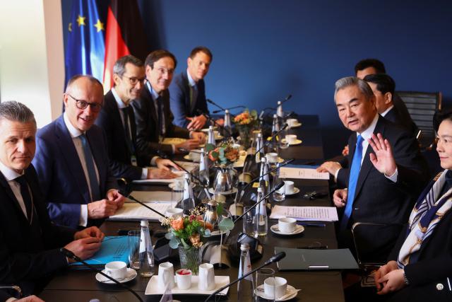 14 February 2026, Bavaria, Munich: German Chancellor Friedrich Merz (2nd R) and Chinese Foreign Minister Wang Yi (2nd R) attend a joint meeting on the sidelines of the Munich Security Conference. Photo: Thilo Schmuelgen/Reuters/Pool/dpa