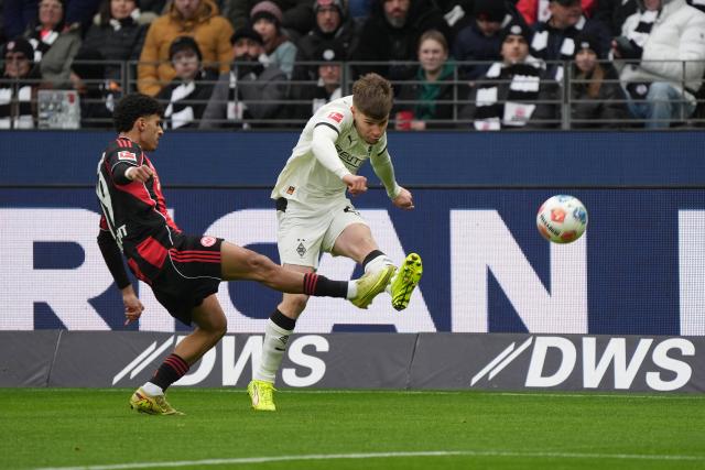 14 February 2026, Hesse, Frankfurt_Main: Eintracht Frankfurt's Ayoube Amaimouni-Echghouyab and Moenchengladbach's Lukas Ullrich battle for the ball during the German Bundesliga soccer match between Eintracht Frankfurt and Borussia Moenchengladbach at Deutsch Bank Park. Photo: Marc Schüler/dpa - IMPORTANT NOTE: In accordance with the regulations of the DFL German Football League and the DFB German Football Association, it is prohibited to utilize or have utilized photographs taken in the stadium and/or of the match in the form of sequential images and/or video-like photo series.