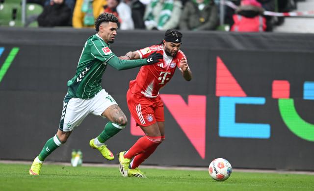 14 February 2026, Bremen: Bayern Munich's Serge Gnabry and Werder Bremen's Justin Njinmah (L) battle for the ball during the German Bundesliga soccer match between Werder Bremen and Bayern Munich at Weserstation. Photo: Carmen Jaspersen/dpa - IMPORTANT NOTE: In accordance with the regulations of the DFL German Football League and the DFB German Football Association, it is prohibited to utilize or have utilized photographs taken in the stadium and/or of the match in the form of sequential images and/or video-like photo series.