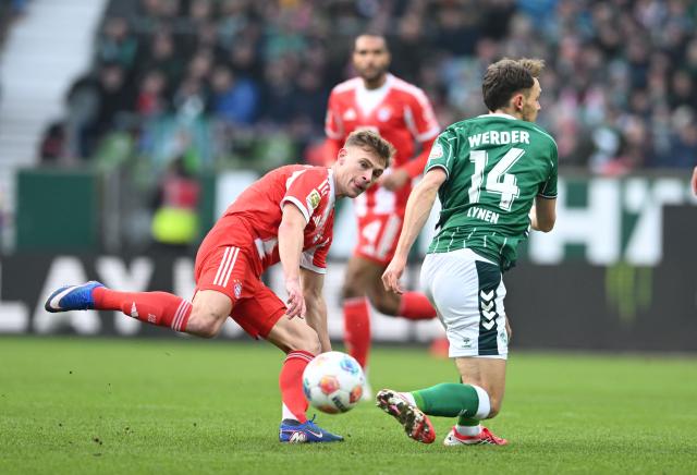 14 February 2026, Bremen: Bayern Munich's Joshua Kimmich and Werder Bremen's Senne Lynen battle for the ball during the German Bundesliga soccer match between Werder Bremen and Bayern Munich at Weserstation. Photo: Carmen Jaspersen/dpa - IMPORTANT NOTE: In accordance with the regulations of the DFL German Football League and the DFB German Football Association, it is prohibited to utilize or have utilized photographs taken in the stadium and/or of the match in the form of sequential images and/or video-like photo series.