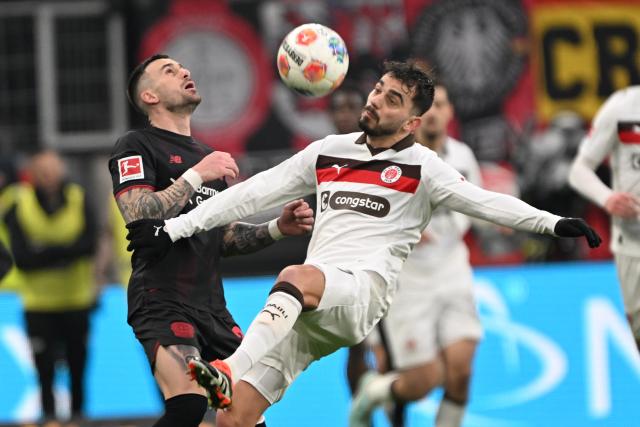 14 February 2026, North Rhine-Westphalia, Leverkusen: Leverkusen's Aleix GarcIa and St. Pauli's Danel Sinani battle for the ball during the German Bundesliga soccer match between Bayer Leverkusen and FC St. Pauli at BayArena. Photo: Federico Gambarini/dpa - IMPORTANT NOTE: In accordance with the regulations of the DFL German Football League and the DFB German Football Association, it is prohibited to utilize or have utilized photographs taken in the stadium and/or of the match in the form of sequential images and/or video-like photo series.