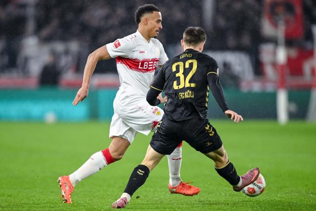 14 February 2026, Baden-Württemberg, Stuttgart: Stuttgart's Jamie Leweling and Cologne's Kristoffer Lund battle for the ball during the German Bundesliga soccer match between VfB Stuttgart and 1. FC Cologne at MHPArena. Photo: Harry Langer/dpa - IMPORTANT NOTE: In accordance with the regulations of the DFL German Football League and the DFB German Football Association, it is prohibited to utilize or have utilized photographs taken in the stadium and/or of the match in the form of sequential images and/or video-like photo series.