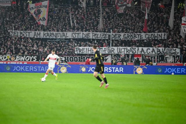 14 February 2026, Baden-Württemberg, Stuttgart: Stuttgart's fans hold a banner with anti police words during the German Bundesliga soccer match between VfB Stuttgart and 1. FC Cologne at MHPArena. Photo: Harry Langer/dpa - IMPORTANT NOTE: In accordance with the regulations of the DFL German Football League and the DFB German Football Association, it is prohibited to utilize or have utilized photographs taken in the stadium and/or of the match in the form of sequential images and/or video-like photo series.