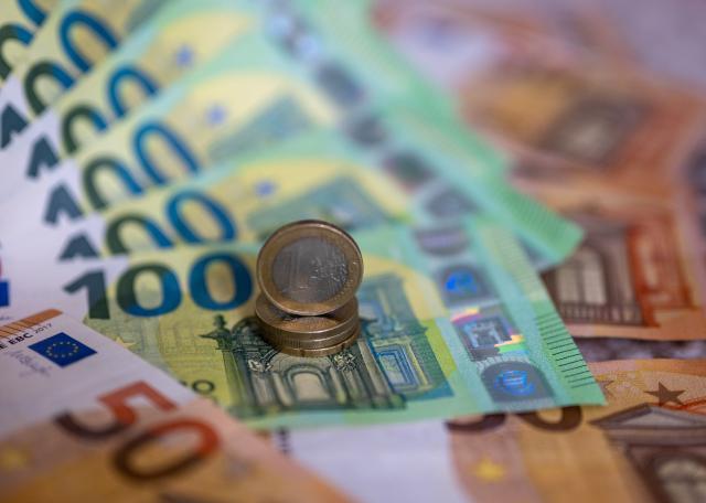 FILED - 21 August 2023, Berlin: Banknotes with the value of 100 and 50 euros and coins are lying on a table. Photo: Monika Skolimowska/dpa