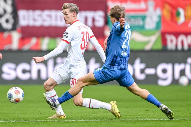 15 February 2026, Bavaria, Augsburg: Augsburg's Anton Kade (L) and Heidenheim's Hennes Behrens battle for the ball during the German Bundesliga soccer match between FC Augsburg and 1. FC Heidenheim at WWK Arena. Photo: Harry Langer/dpa - WICHTIGER HINWEIS: Gemäß den Vorgaben der DFL Deutsche Fußball Liga bzw. des DFB Deutscher Fußball-Bund ist es untersagt, in dem Stadion und/oder vom Spiel angefertigte Fotoaufnahmen in Form von Sequenzbildern und/oder videoähnlichen Fotostrecken zu verwerten bzw. verwerten zu lassen.