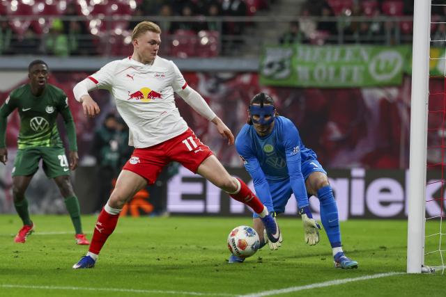 15 February 2026, Saxony, Leipzig: Leipzig's Conrad Harder (L) and Wolfsburg goalkeeper Kamil Grabara battle for the ball during the German Bundesliga soccer match between RB Leipzig and VfL Wolfsburg at Red Bull Arena. Photo: Jan Woitas/dpa - WICHTIGER HINWEIS: Gemäß den Vorgaben der DFL Deutsche Fußball Liga bzw. des DFB Deutscher Fußball-Bund ist es untersagt, in dem Stadion und/oder vom Spiel angefertigte Fotoaufnahmen in Form von Sequenzbildern und/oder videoähnlichen Fotostrecken zu verwerten bzw. verwerten zu lassen.