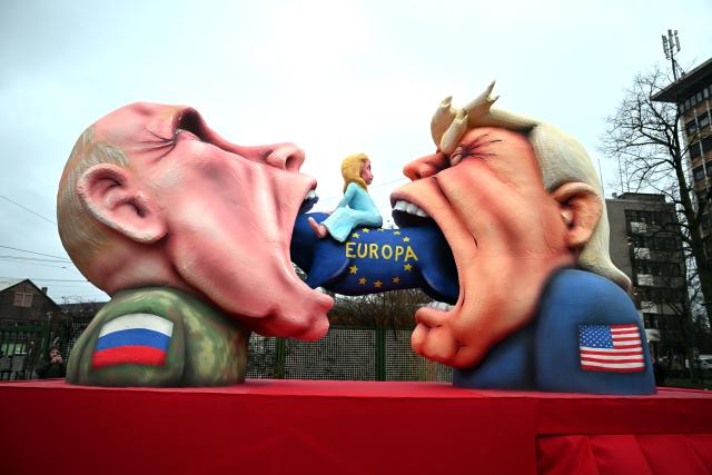 16 February 2026, North Rhine-Westphalia, Cologne: A themed float with Putin and Trump trying to eat Europe drives out of the float construction hall. Rose Monday on the Rhine is the highlight of the Rhenish carnival season with traditional parades in Cologne, Düsseldorf and Mainz, among others Photo: Federico Gambarini/dpa