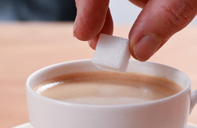 FILED - 06 August 2025, Baden-Württemberg, Stuttgart: Cube sugar from Südzucker is held over a coffee cup. Photo: Bernd Weißbrod/dpa