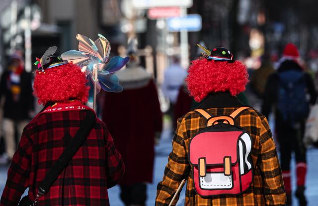 16 February 2026, Rhineland-Palatinate, Mainz: Two people dressed as clowns walk towards the Rose Monday parade. The Rose Monday parade is the highlight of the Mainz carnival. Photo: Hannes P. Albert/dpa