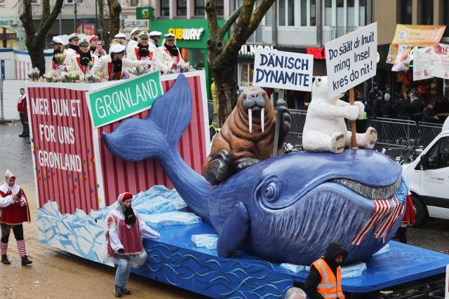 16 February 2026, North Rhine-Westphalia, Cologne: A float with a Greenland theme and a tattered US flag in a whale's mouth takes part in the Rose Monday parade in Cologne. Rose Monday on the Rhine is the highlight of the Rhenish carnival season with its traditional parades. Photo: Oliver Berg/dpa