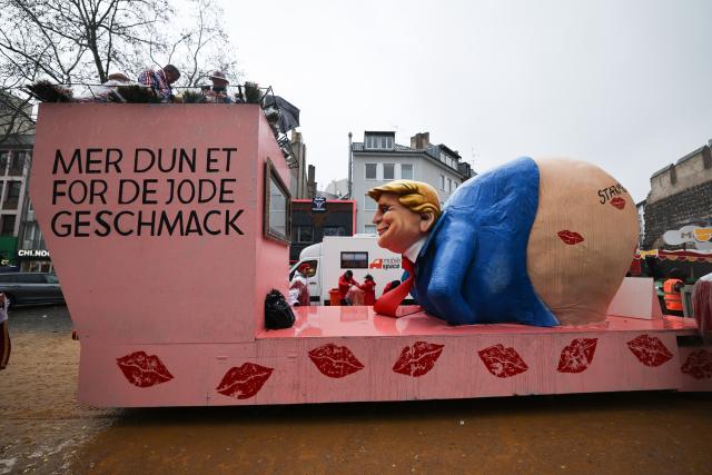 16 February 2026, North Rhine-Westphalia, Cologne: A float showing US President Trump with a bare bottom takes part in the Rose Monday parade in Cologne. Rose Monday on the Rhine is the highlight of the Rhineland carnival season with its traditional parades. Photo: Oliver Berg/dpa