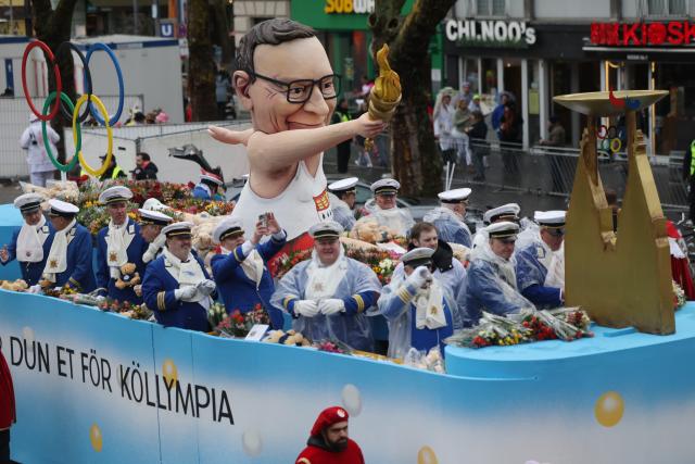 16 February 2026, North Rhine-Westphalia, Cologne: A float featuring the Lord Mayor with the Olympic flame takes part in the Rose Monday parade in Cologne. Rose Monday on the Rhine is the highlight of the Rhenish carnival season with its traditional parades. Photo: Oliver Berg/dpa