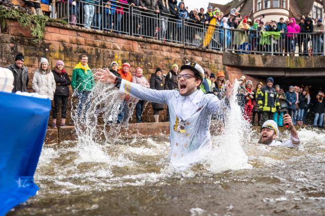 16 February 2026, Baden-Wuerttemberg, Schramberg: Sebastian Boehler and Marcel Maurer cycle and swimm under the motto "30 years of AIDA" during the Da-Bach-na-Fahrt race on the Schiltach. Participants ride their "Zuberboote" (wooden tubs) along the 400-meter route. Photo: Silas Stein/dpa