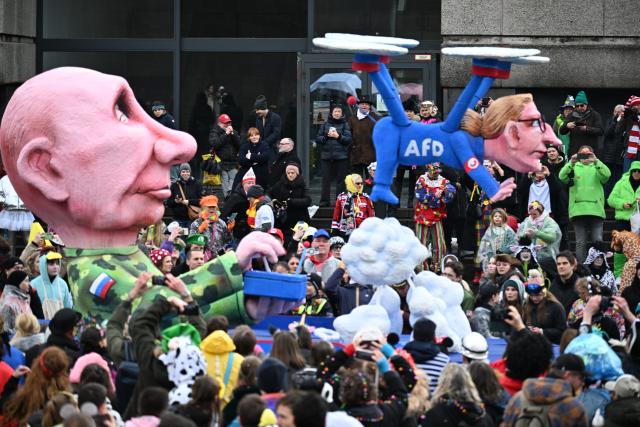 16 February 2026, North Rhine-Westphalia, Duesseldorf: A float depicting Russian President Vladimir Putin controlling Alice Weidel of the AfD as a drone passes by spectators at the Rose Monday parade in Duesseldorf. Photo: Federico Gambarini/dpa