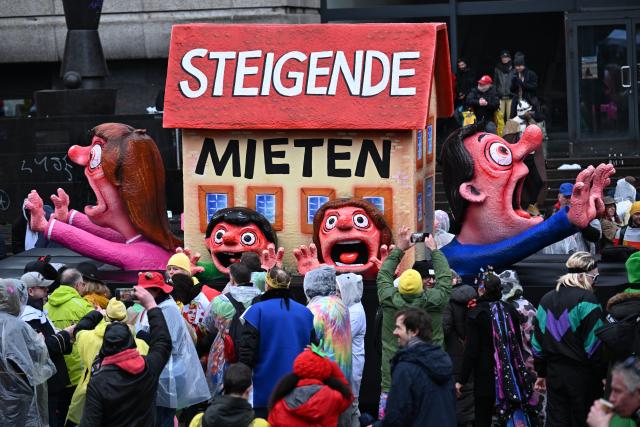 16 February 2026, North Rhine-Westphalia, Duesseldorf: A float themed "rising rents" passes by spectators at the Rose Monday parade in Duesseldorf. Photo: Federico Gambarini/dpa