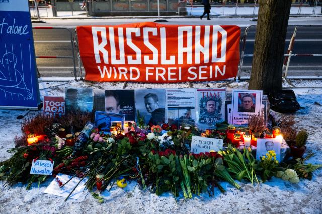 16 February 2026, Berlin: Flowers, candles, and pictures of Alexei Navalny lie in front of the Russian Embassy during a memorial service for the late Kremlin opponent. Two years after the death of Kremlin opponent Navalny, many people in Russia and other countries have commemorated the opposition leader. Photo: Christophe Gateau/dpa