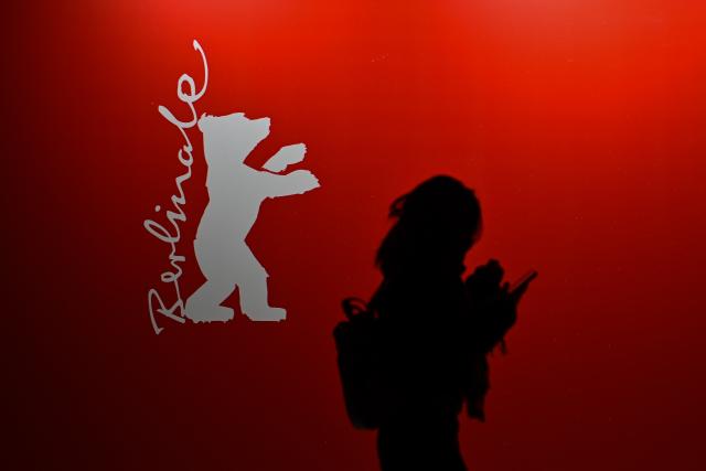 16 February 2026, Berlin: A woman walks past a Berlinale logo before the premiere of the film "At the Sea" during the 76th Berlin International Film Festival. Photo: Sebastian Christoph Gollnow/dpa
