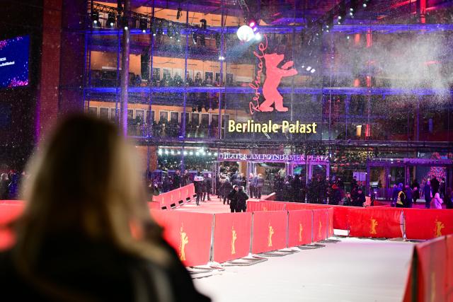 16 February 2026, Berlin: A woman films the Berlinale logo before the premiere of the film "At the Sea" during the 76th Berlin International Film Festival. Photo: Sebastian Christoph Gollnow/dpa
