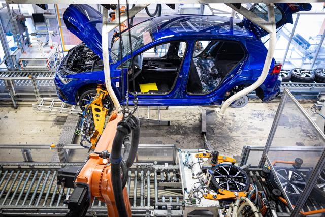 FILED - 23 May 2024, Lower Saxony, Wolfsburg: Robotic arms fit the wheels to a Volkswagen Golf at the VW plant. Germany's industrial sector cut around 124,000 jobs in 2025 as the economy struggles, according to an analysis by consulting firm EY seen by dpa. Photo: Moritz Frankenberg/dpa