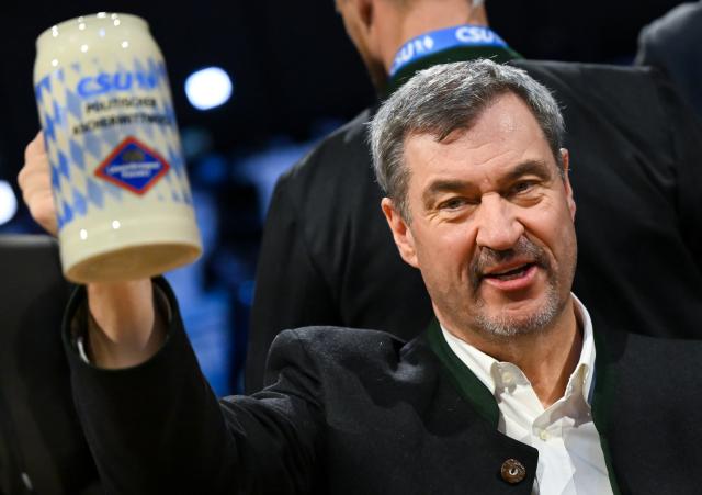 18 February 2026, Bavaria, Passau: Markus Soeder, Minister President of Bavaria and Christian Socila Union (CSU) leader, holds up a beer mug at the CSU's political Ash Wednesday. Photo: Sven Hoppe/dpa