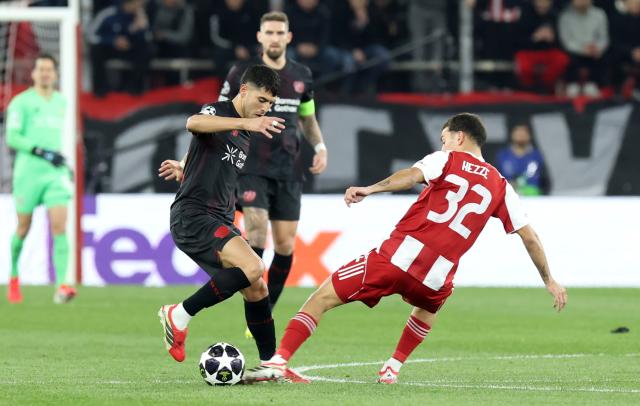 18 February 2026, Piräus: Olympiacos' Santiago Hezze (R) and Leverkusen's Exequiel Palacios battle for the ball during the UEFA Champions League soccer match between Olympiacos F.C. and Bayer 04 Leverkusen at Georgios Karaiskakis Stadium. Photo: Yorgos Karahalis/dpa